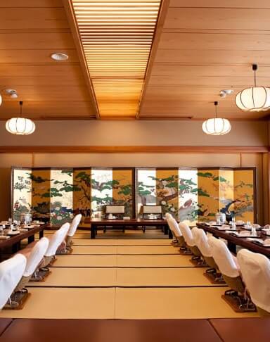 金屏風の前に座卓が並べられている幸本の会場