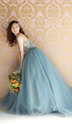 花束を手にスツールに座る新郎の肩に手をのせる新婦